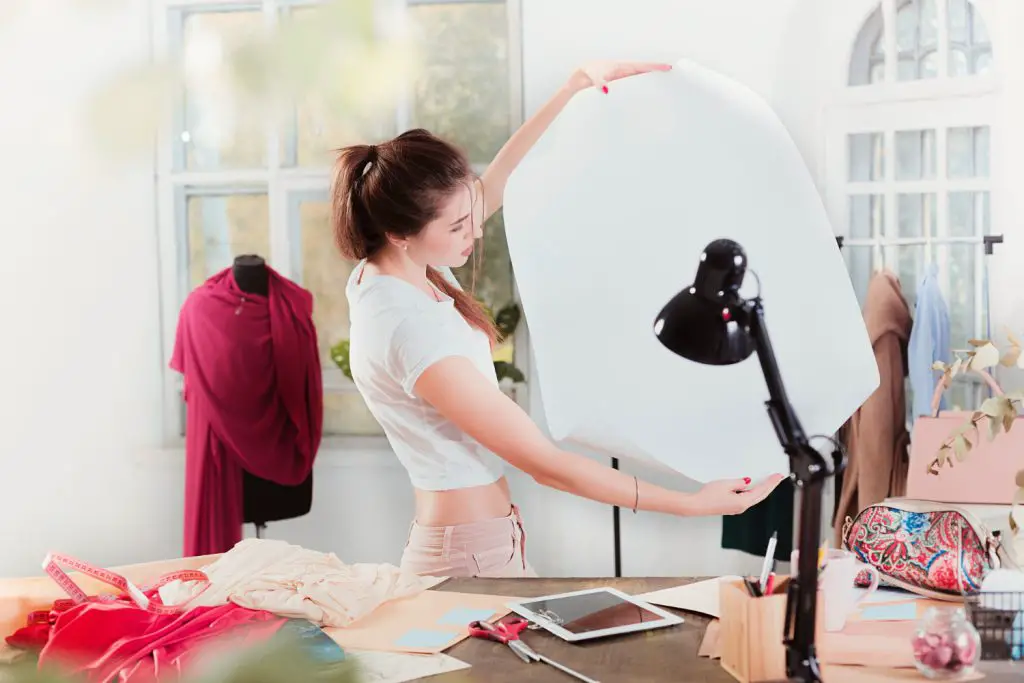 Seorang perempuan sedang melakukan sesi foto produk di studio